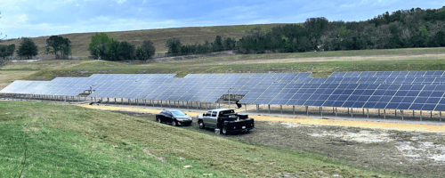Solar farming with two work vehicles parked in the foreground