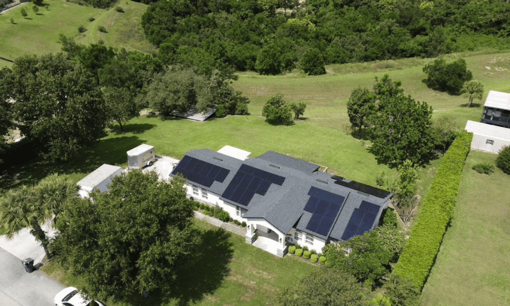 Aerial view of large residential property with solar panels by Castaways Energy, highlighting renewable energy solutions in a lush green environment.