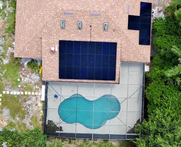 Aerial View of House with Solar Panels on Roof and Screened-In Pool Area | Castaways Energy