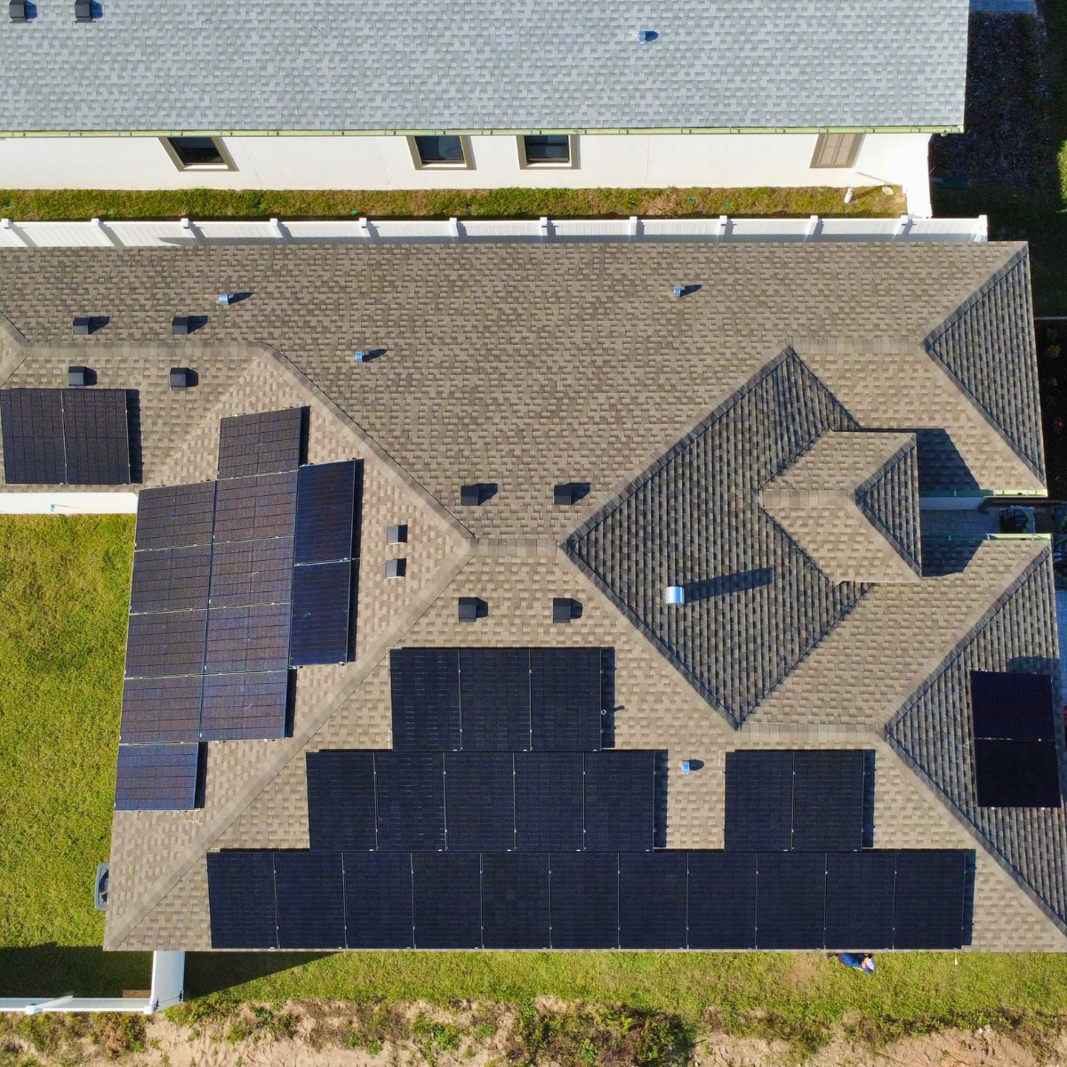 1 Aerial view of a Castaways Energy residential solar installation on a Florida shingle roof with multiple rooftop solar panel arrays.